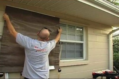 Easy hurricane screens installed by worker for protect glass window