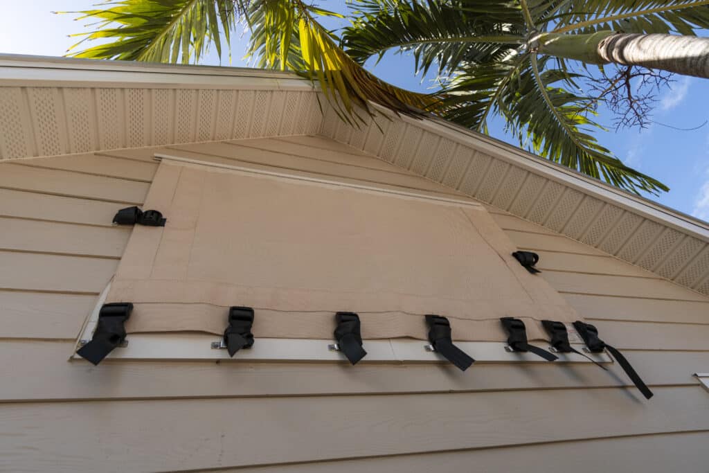 Strap and buckle hurricane screen on a window